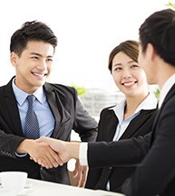 A group of people shaking hands over a table